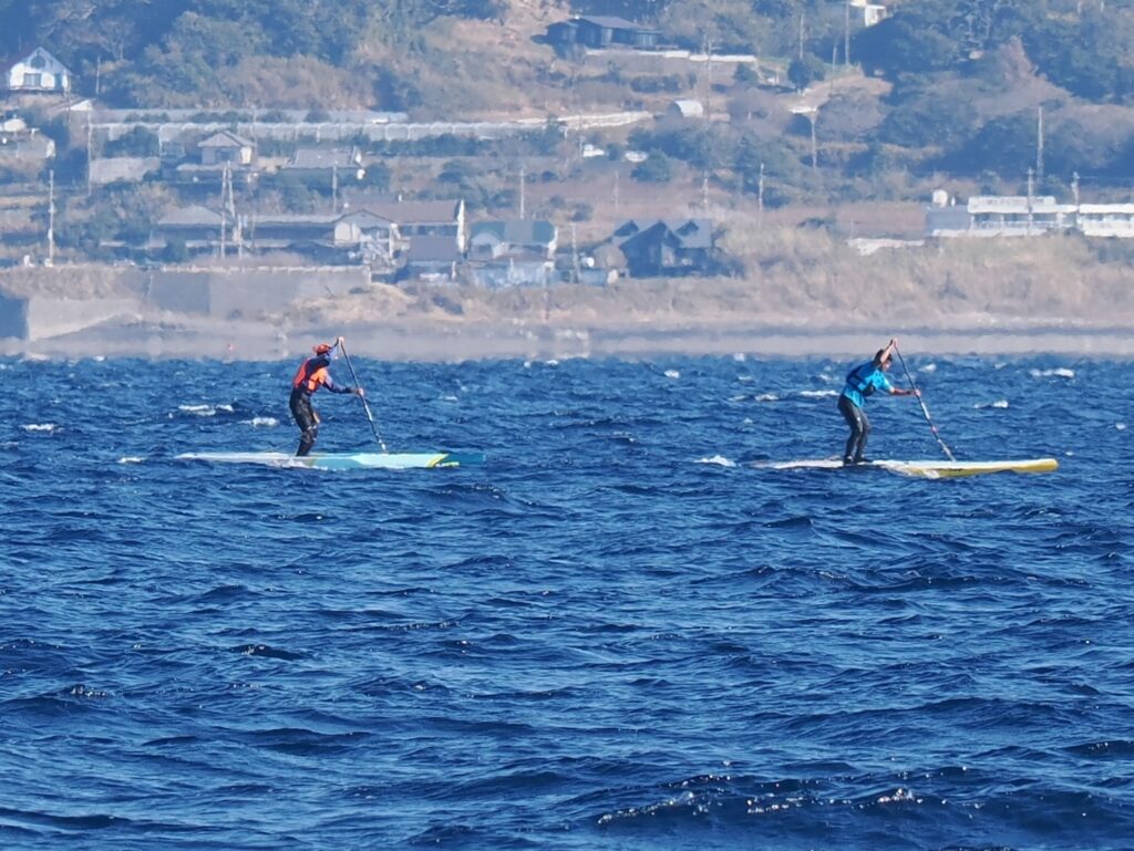 東京湾の千葉県沖をサップで移動する2人。