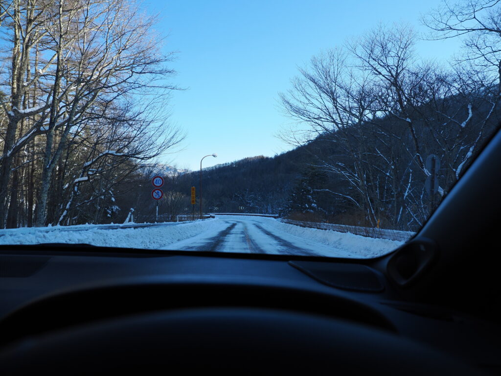 まだ太陽が当たっていない路面。雪も残っていて凍結もあり得る。
