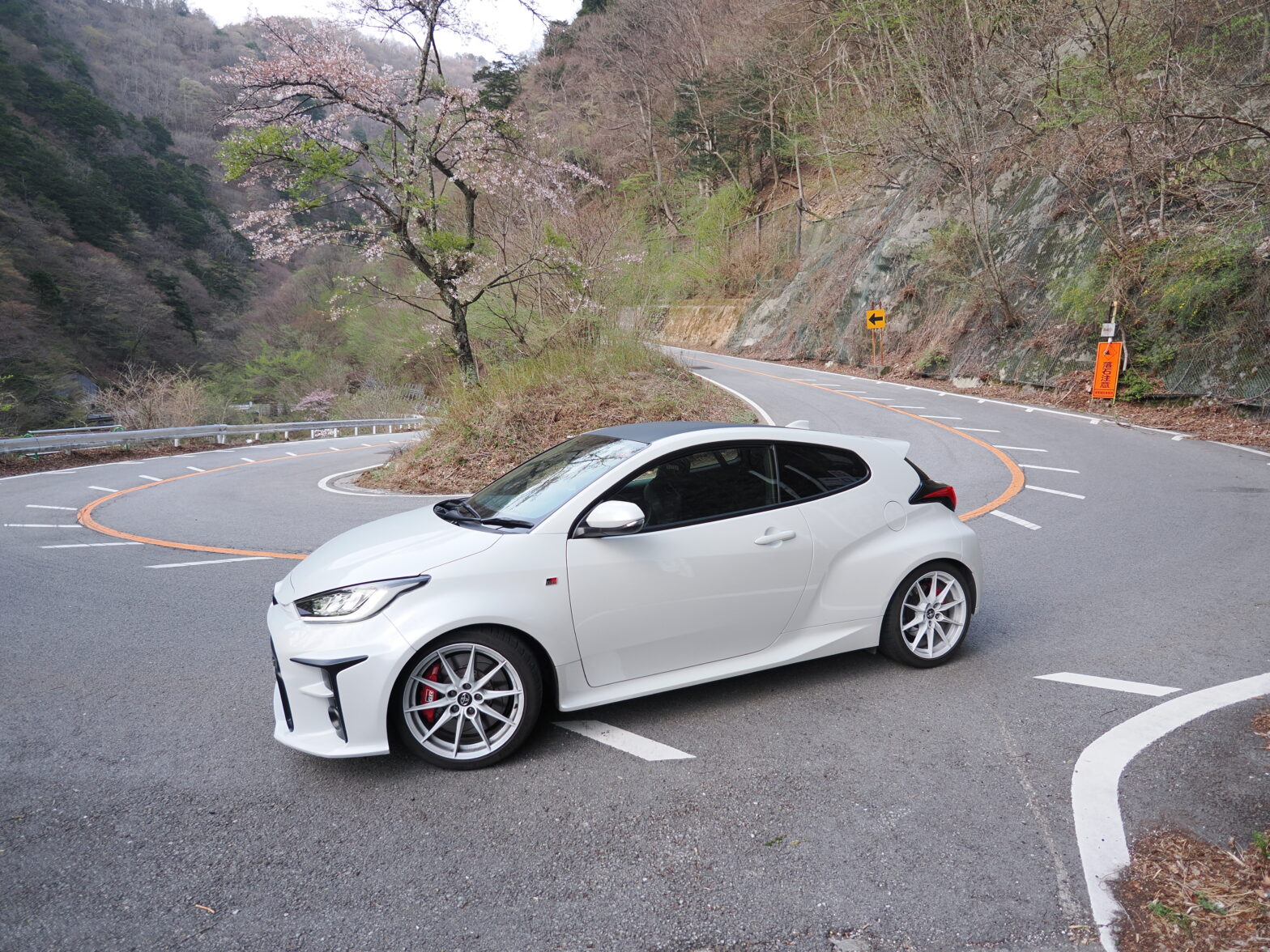 Standing at a hairpin corner with elevation changes, the GR Yaris