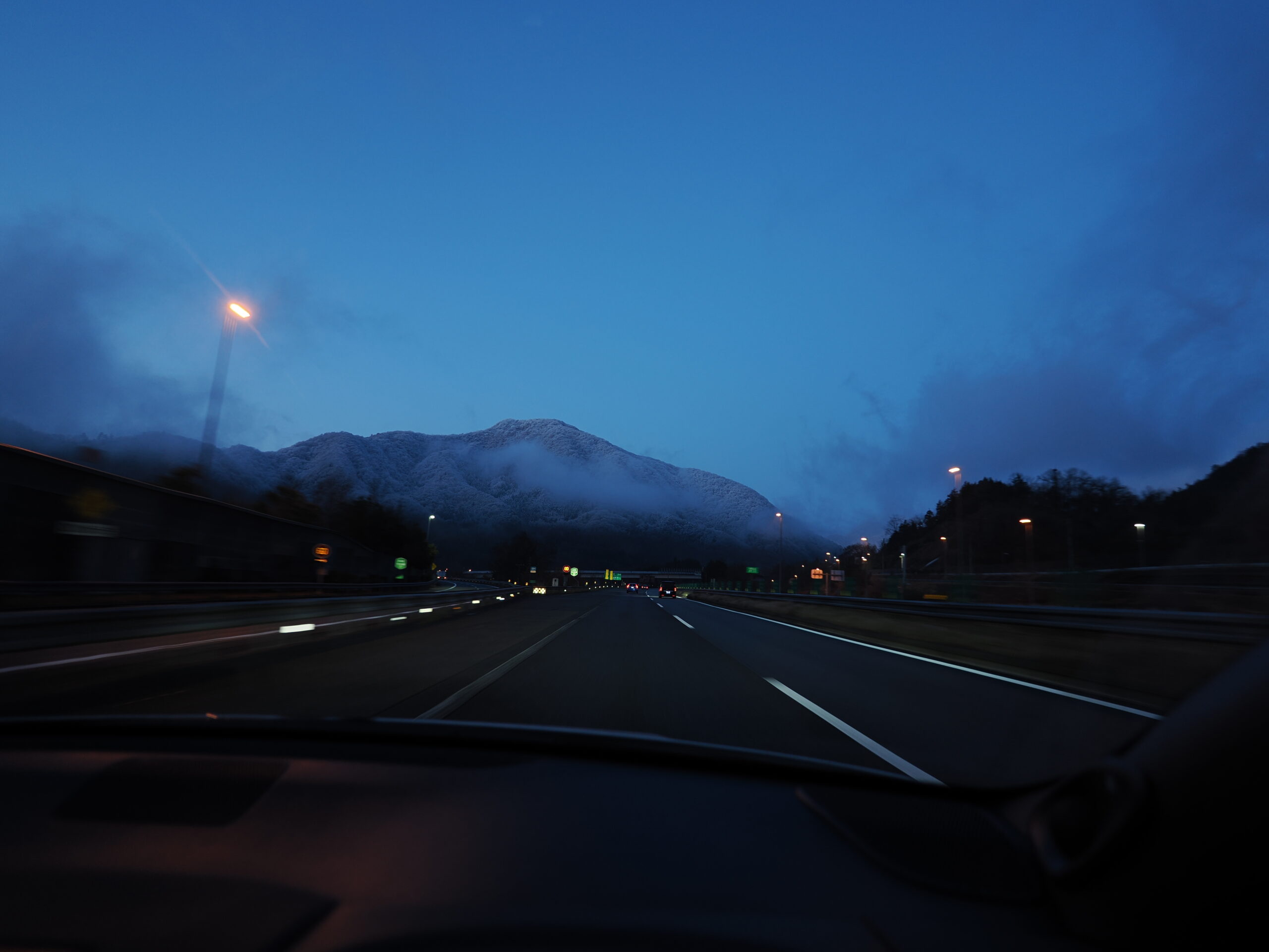ワインディングに向かう途中の高速道路。進行方向の山に雪が見える。
